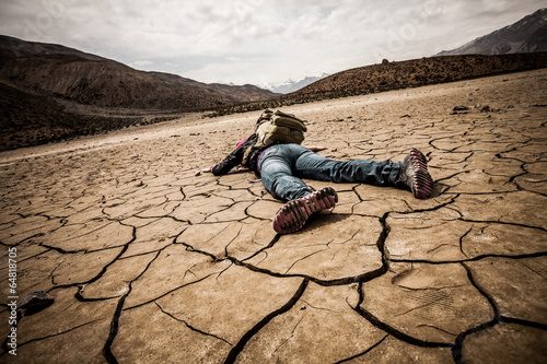 person lays on the dried ground photo