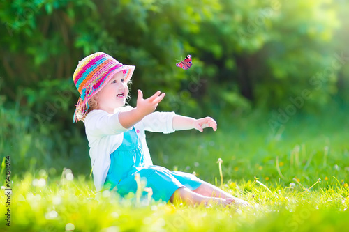 Canvas Print Happy toddler girl playing with butterfly