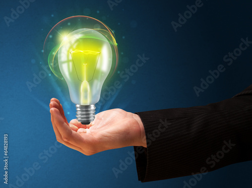 Glowing lightbulb in the hand of a businessman