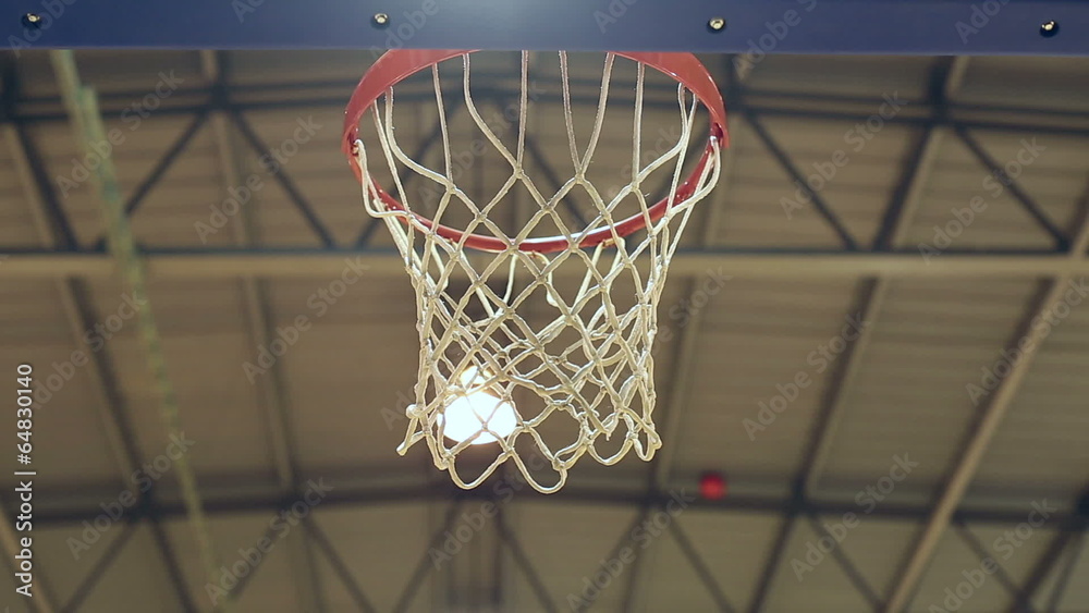 Close shot of basketball scoring through the net