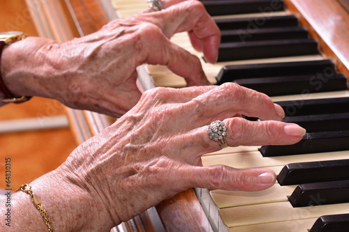 Old woman playing the piano closeup