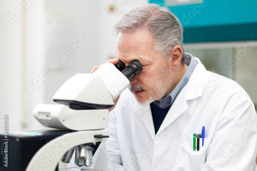 Researcher loooking through microscope