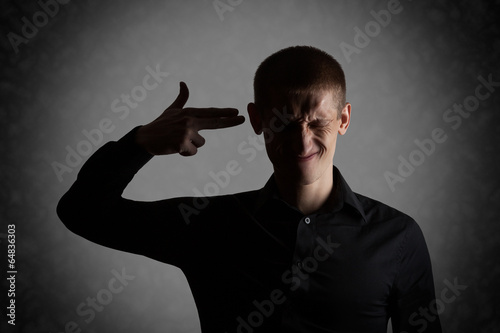 Frustrated young man put an imaginary gun to his head