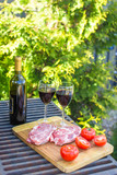 Fresh meat, vegetables and bottle of wine on a picnic outdoors