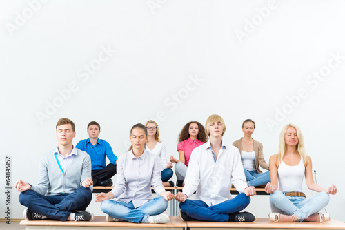 group of young people meditating