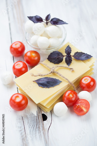 Lasagna ingredients over wooden background, vertical shot