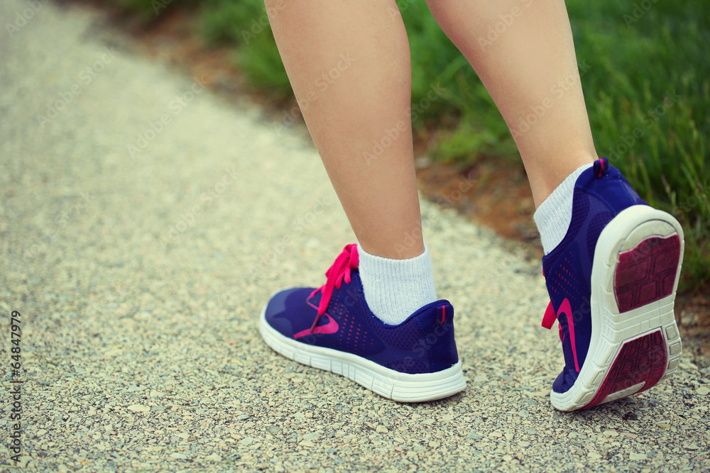 Naklejka premium Runner Female Feet Running on Road. Jog
