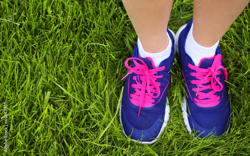 Sport Footwear on Female Feet on Green Grass. Closeup Running