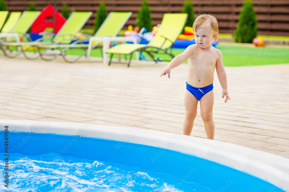 Little boy pointing at the water in the swimming pool