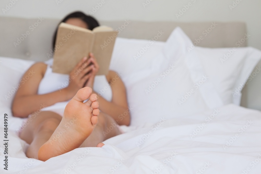 Woman lying on bed reading Woman lying on bed reading