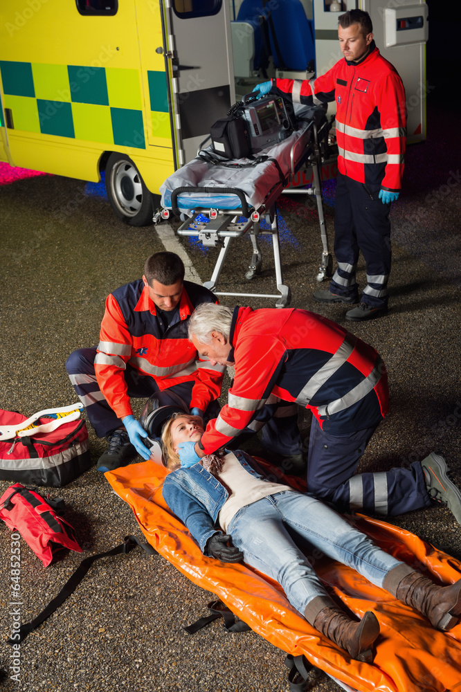 Emergency team helping injured motorcycle driver Emergency team helping injured motorcycle driver