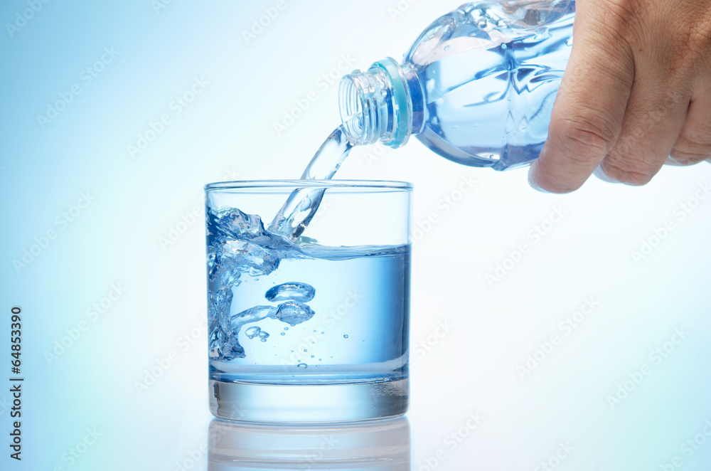 pure water is emptied into a glass of water from bottle pure water is emptied into a glass of water from bottle