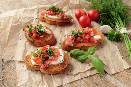 Top view of homemade bruschetta with tomato mozarella and herbs