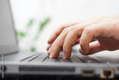 macro of male hands typing on a laptop