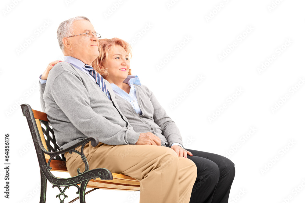 Senior couple hugging and looking in the distance Senior couple hugging and looking in the distance