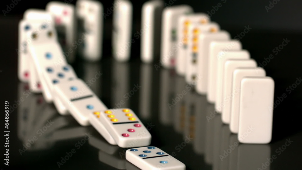 Finger pushing over colourful dominoes