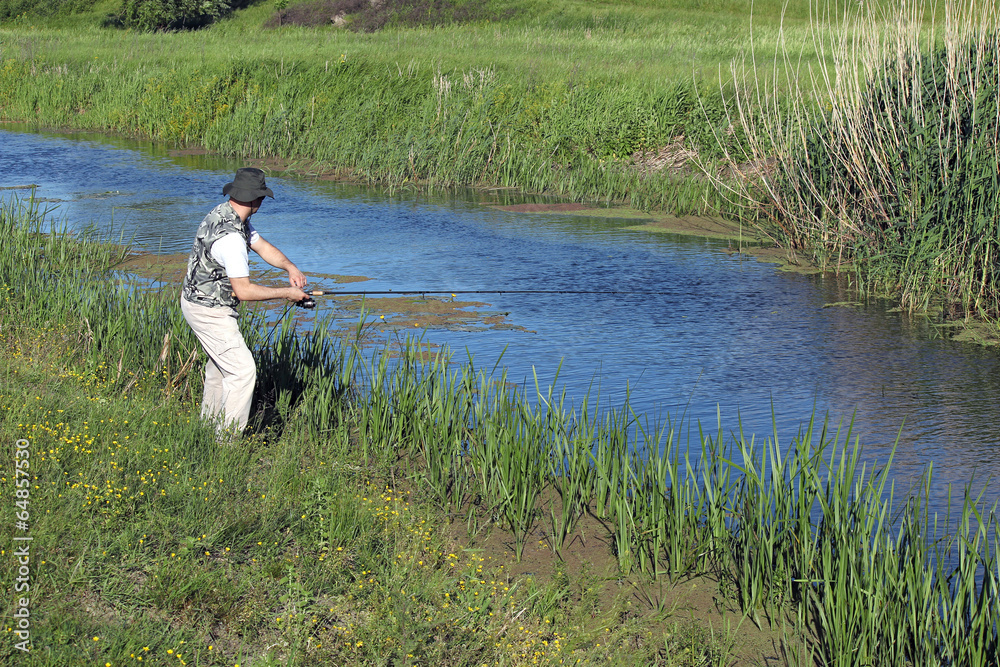 Fototapeta premium fisherman with fishing rod on river