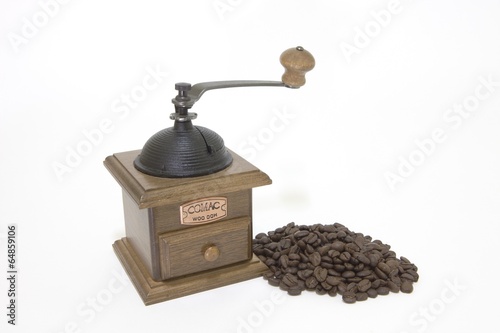 Pile of roasted coffee beans with a grinder