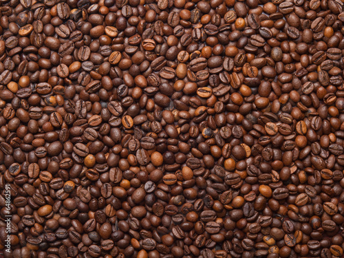 Numerous coffee beans which have been scattered all over the sur