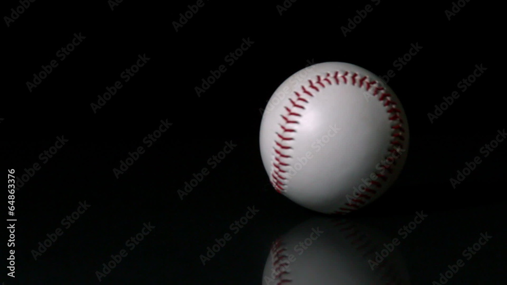 Baseball spinning on black surface