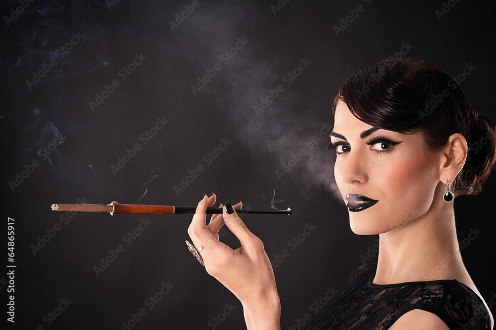Fototapeta premium attractive woman with dark makeup smokes a cigarette