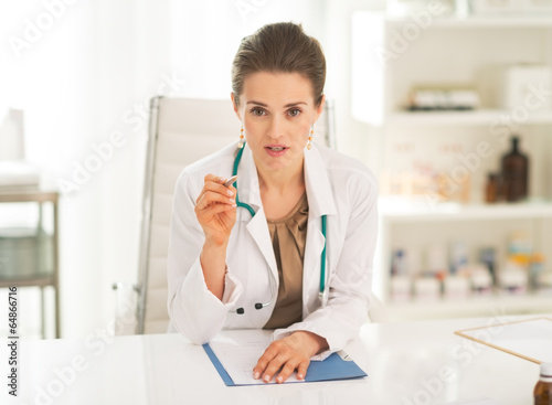 Medical doctor woman sitting in office and explaining