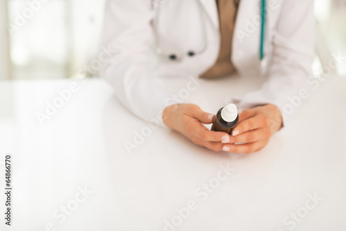 Closeup on medical doctor woman holding medicine bottle