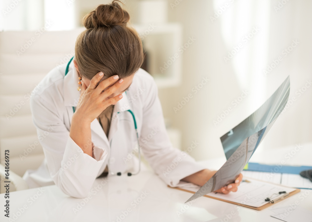 Stressed medical doctor woman with fluorography in office Stressed medical doctor woman with fluorography in office