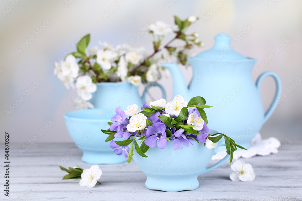 Beautiful spring flowers in cups on wooden table Beautiful spring flowers in cups on wooden table