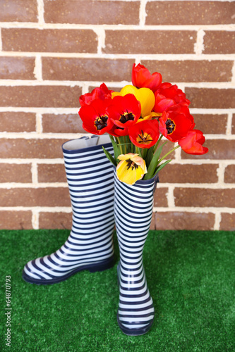 Fototapeta Naklejka Na Ścianę i Meble -  Composition of colorful tulips in rain boots