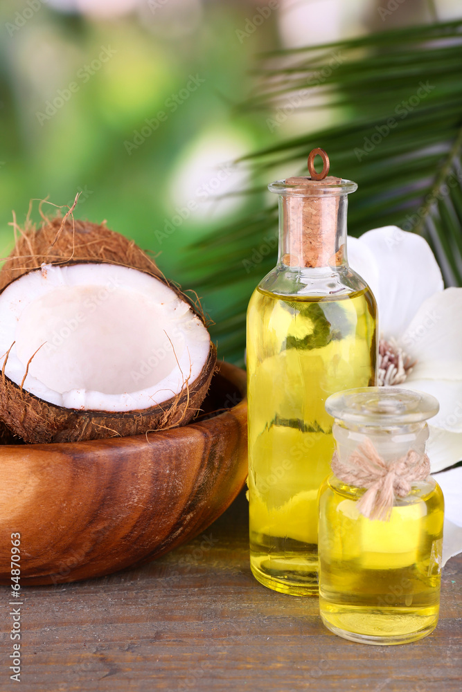 Coconuts and coconut oil on wooden table, on nature background Coconuts and coconut oil on wooden table, on nature background