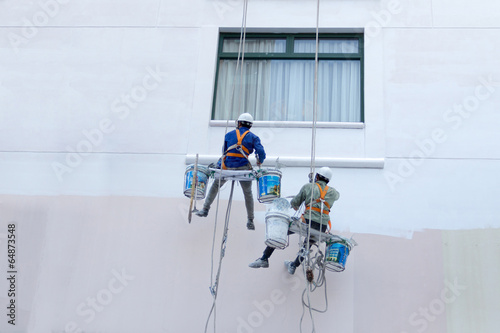 Two worker are painting the color in high buildings - Rise occup