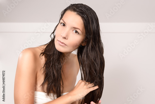 Junge Frau in Unterwäsche pflegt ihre Haare photo