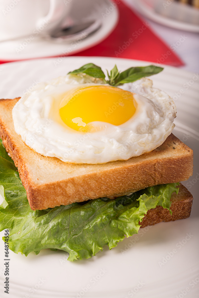 Breakfast: fried egg on the white bread with fresh salad Breakfast: fried egg on the white bread with fresh salad