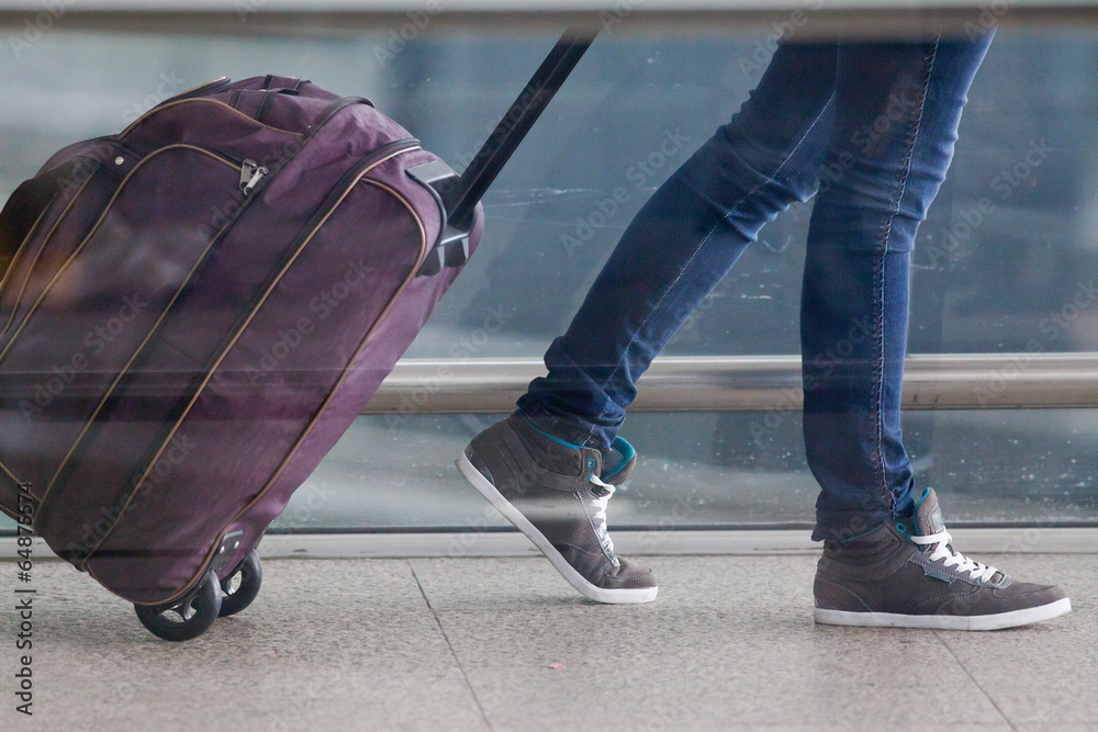 Fototapeta premium Woman carries your luggage at the airport terminal