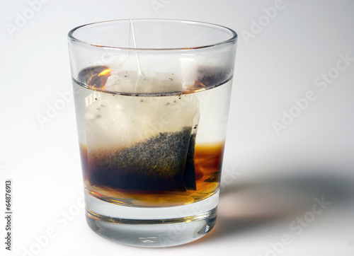 Sugar cubes and tea bag in glass of boiling water