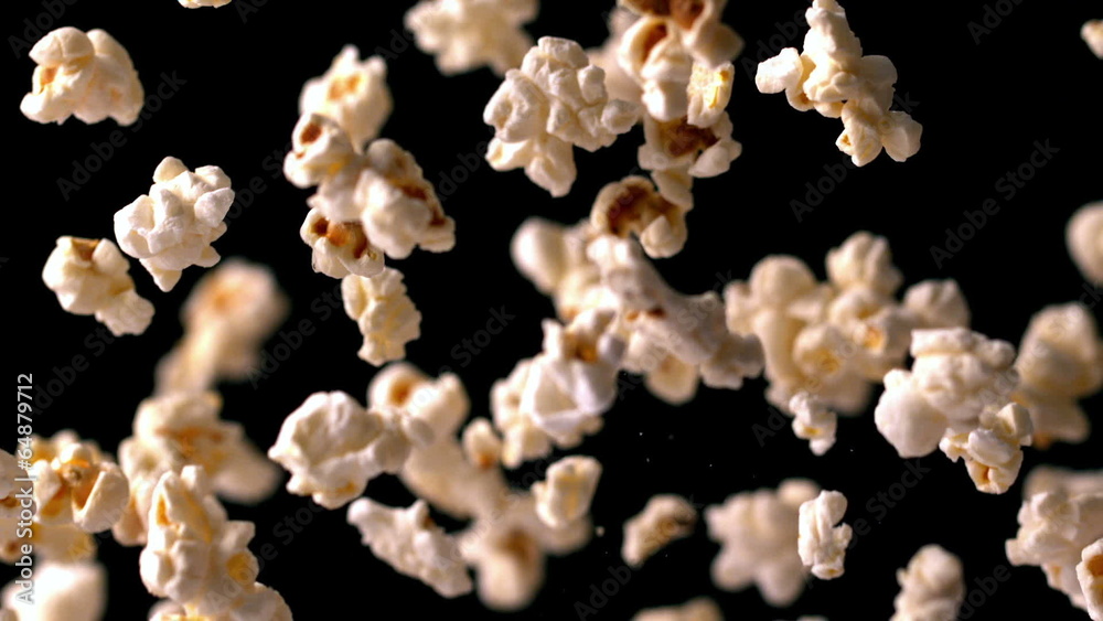 Popcorn bouncing against black background