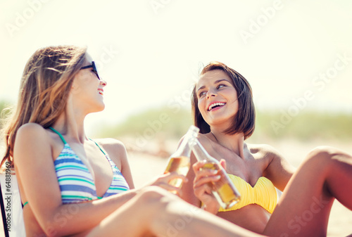 girls with drinks on the beach chairs © Syda Productions