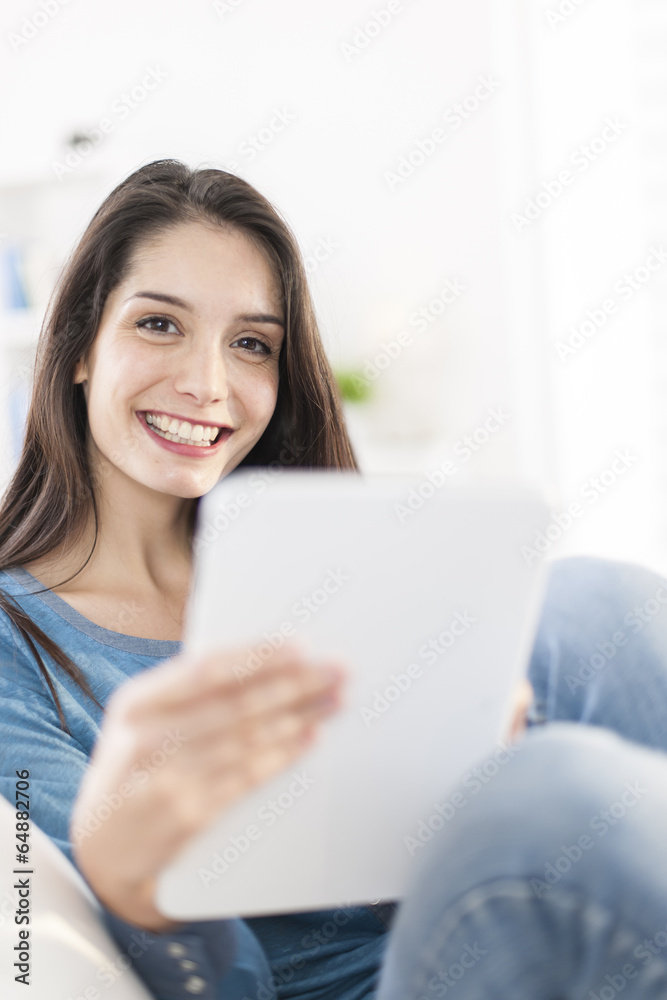 beautiful young woman using digital tablet on a sofa at home beautiful young woman using digital tablet on a sofa at home
