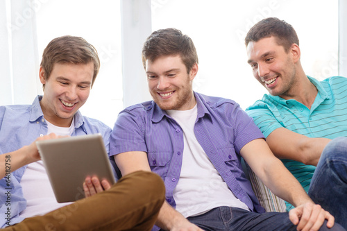 smiling friends with tablet pc computers at home © Syda Productions