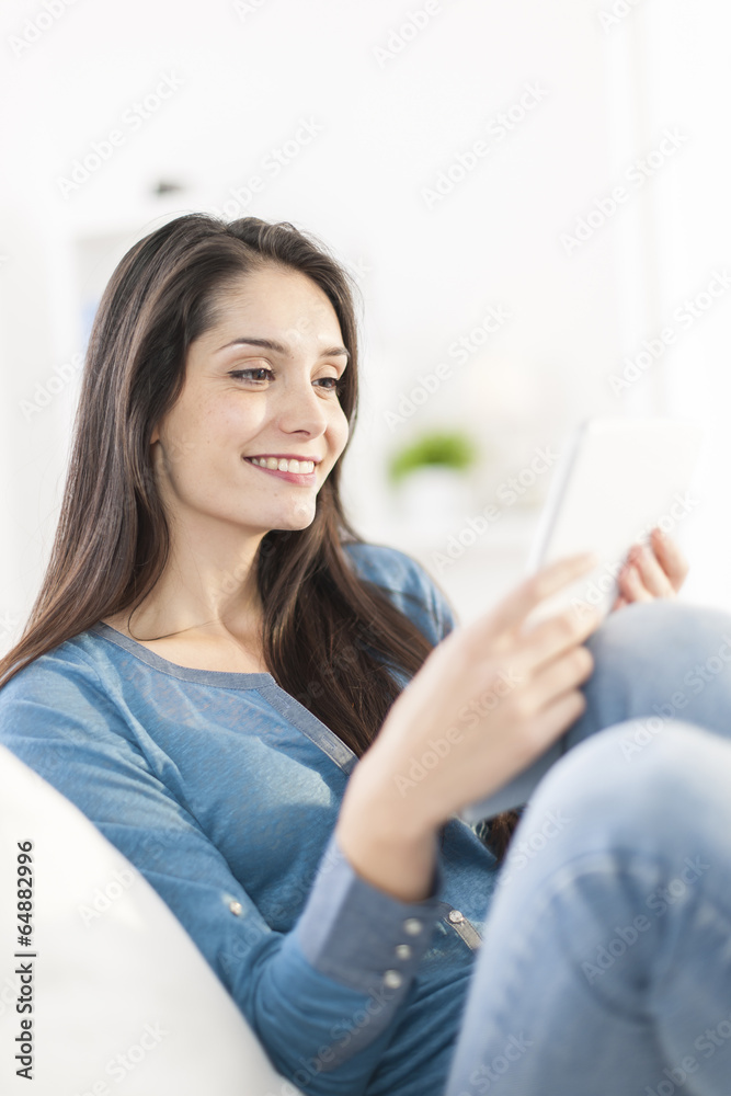 beautiful young woman using digital tablet on a sofa at home beautiful young woman using digital tablet on a sofa at home