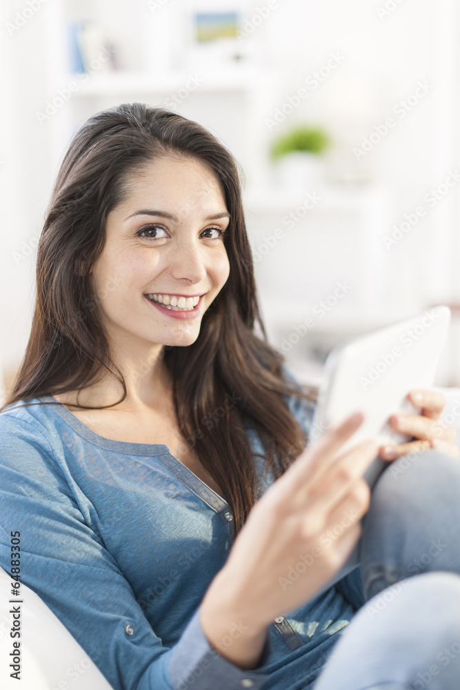 beautiful young woman using digital tablet on a sofa at home beautiful young woman using digital tablet on a sofa at home