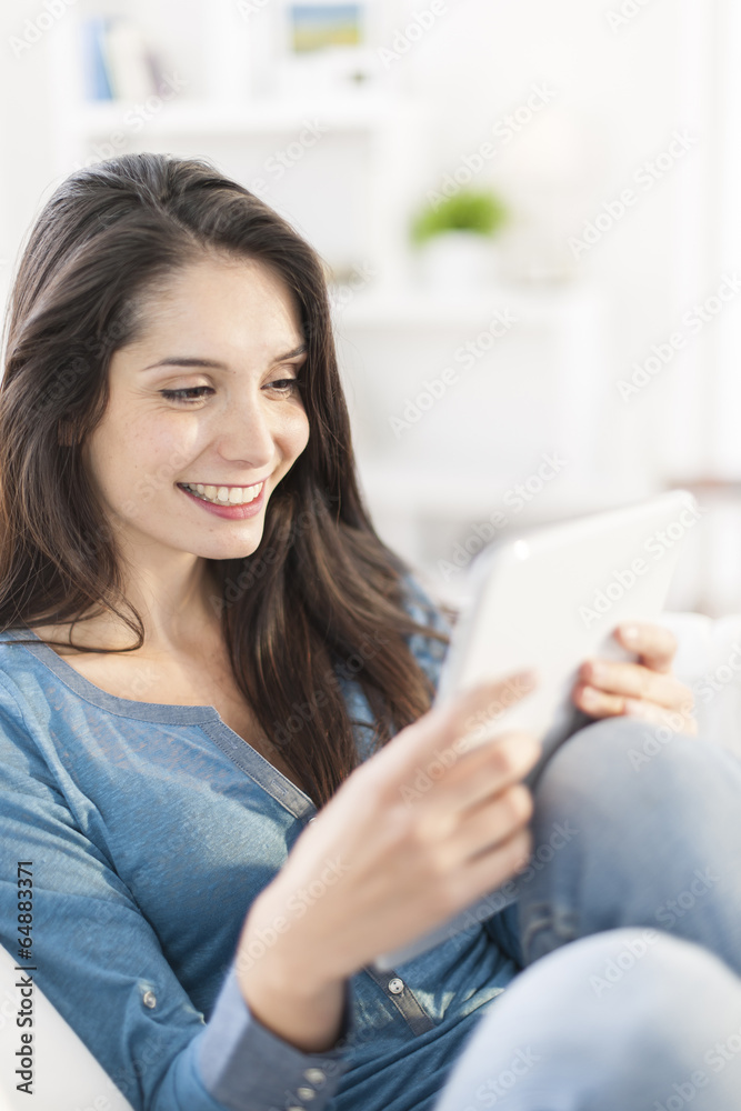 beautiful young woman using digital tablet on a sofa at home beautiful young woman using digital tablet on a sofa at home