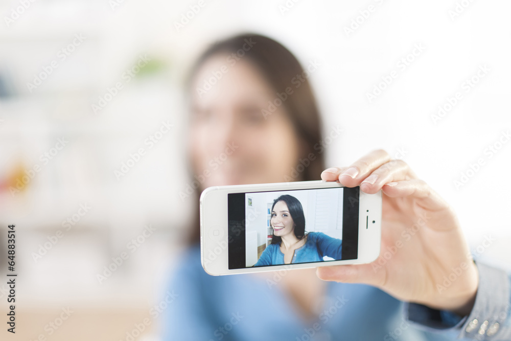 beautiful young woman taking a selfie with her smartphone