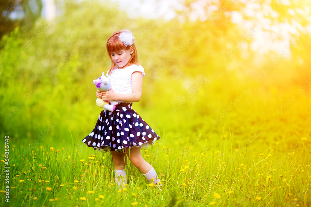 Happy little girl with a toy in the hands of having fun in the S