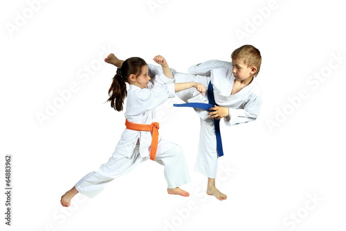 Girl and boy in karategi are training paired exercises karate