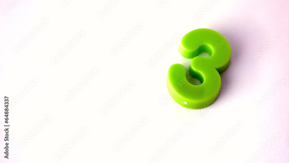 Number three falling onto white surface Number three falling onto white surface