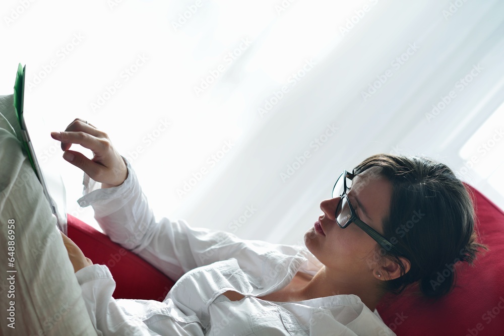 Naklejka premium woman using tablet pc at home