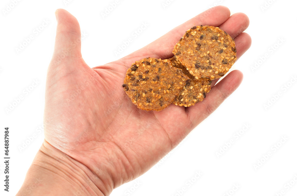 Hand holding three sesame crackers on white background Hand holding three sesame crackers on white background