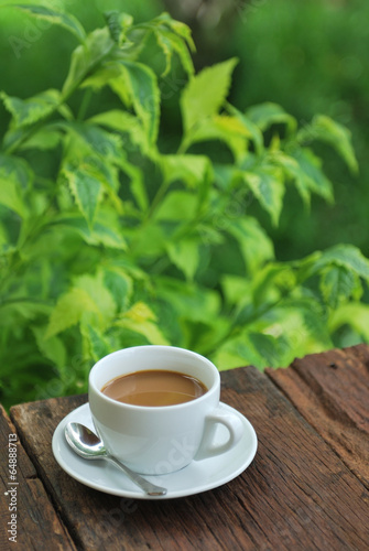 coffee cup on wood table with green background